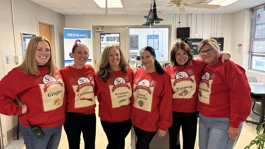 Staff members wearing spice themed costumes that say spice girls on them.
