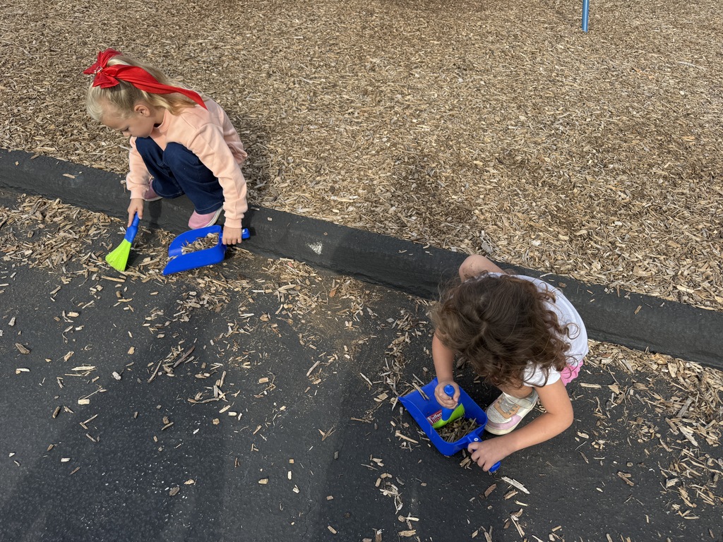 Students cleaning up mulch on the playground