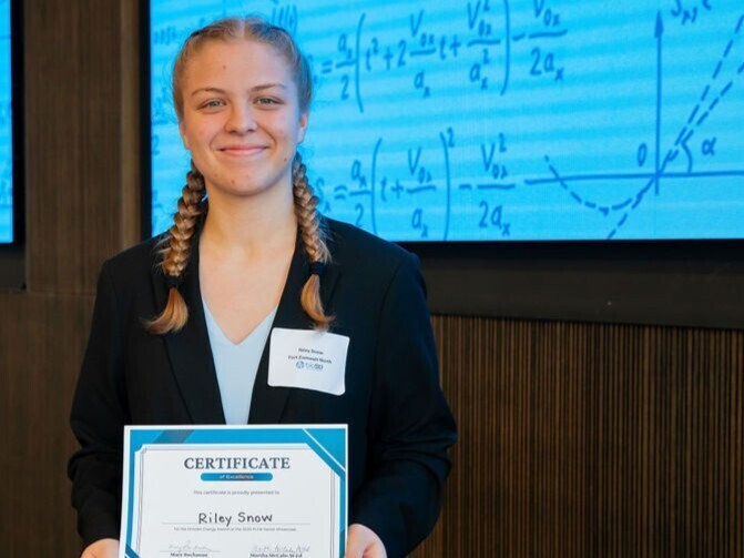 student poses with award