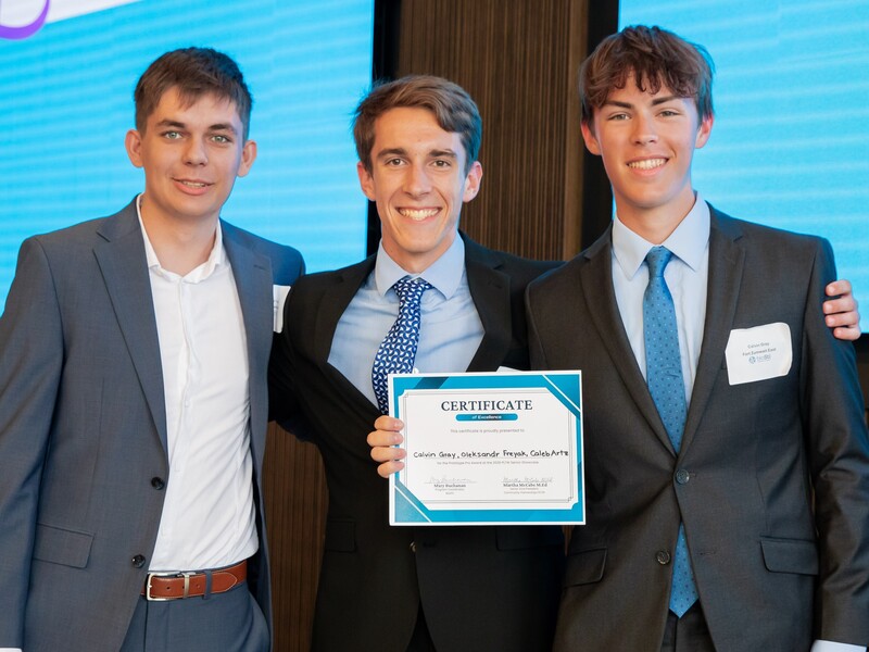 students pose with award