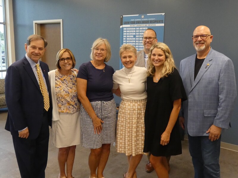 Several of the founders and one of the first FZ GYOT awardees pose in front of the honor board