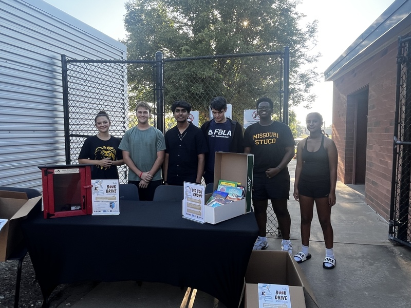 Our Lion students collecting books before the football game
