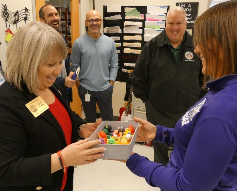 Legislator selects a rubber duck from the teacher's box of prizes