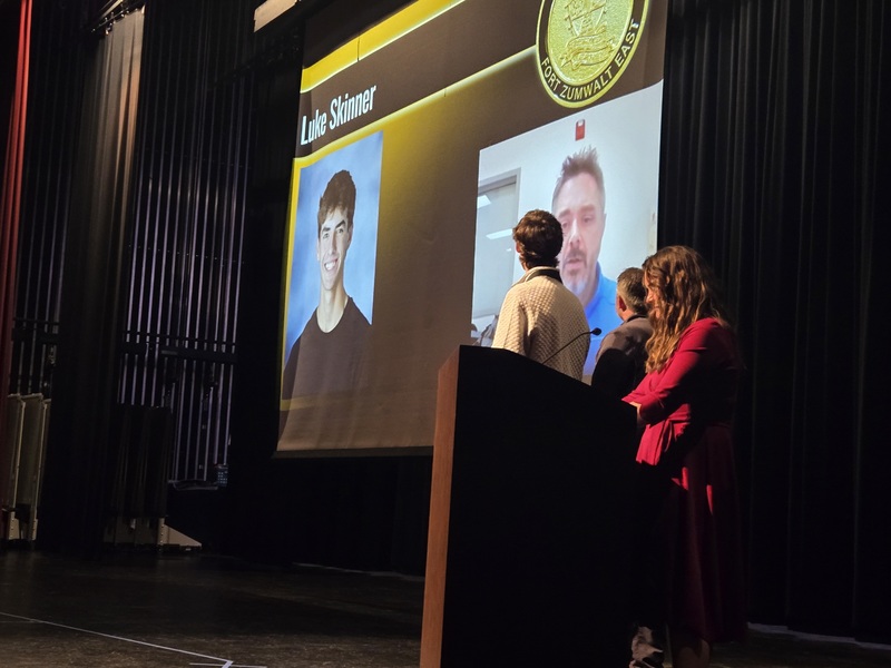 East High stage with Dr. Vaughn and award recipient, Luke Skinner watching the teacher video