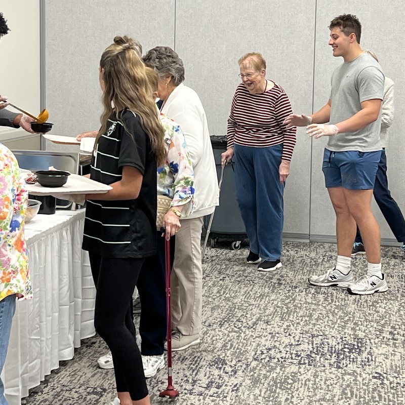 Students assist guests in the buffet line