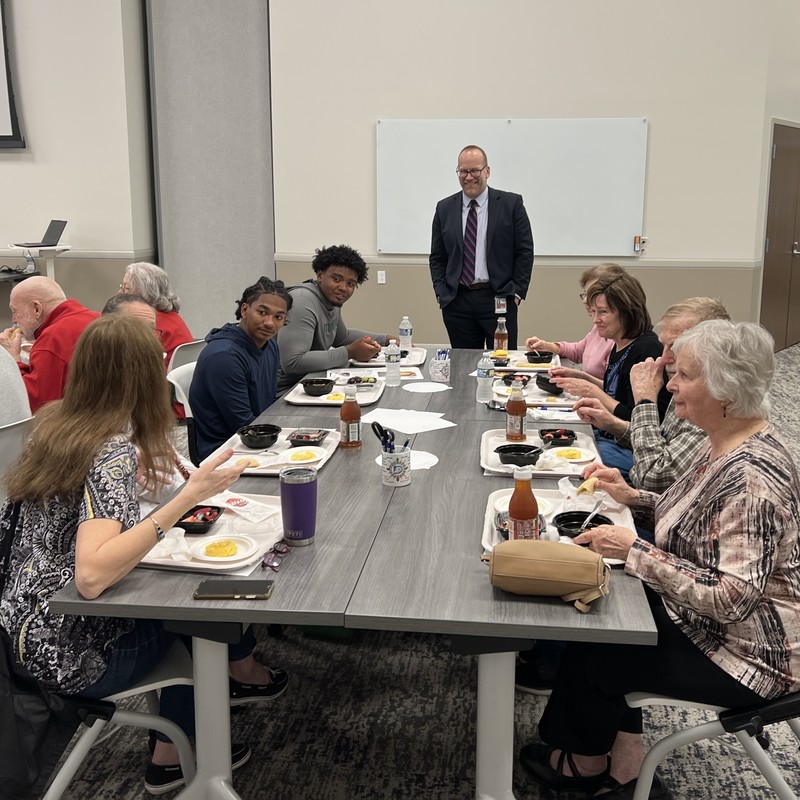 Superintendent mingles with students and guests as they eat lunch toghether