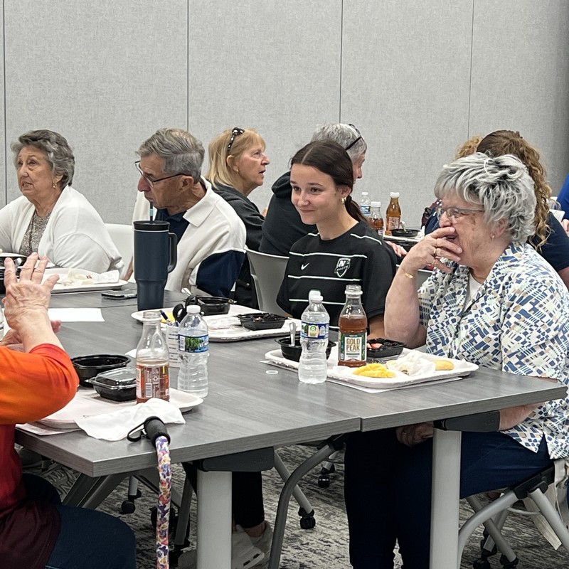 Student and guest share a laugh over lunch