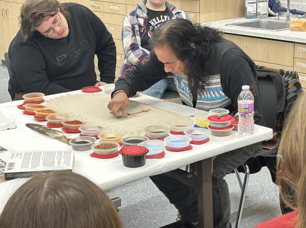 Screenshot 20Dennis Rogers teaches about "Native American sand art" & flute  (at Fosston high school).25-12-19 at 10