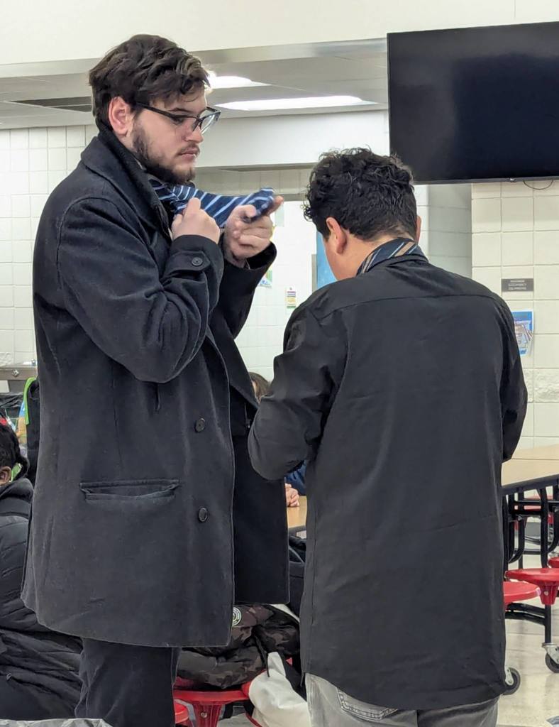 Mr. Geiger helping student tie a tie