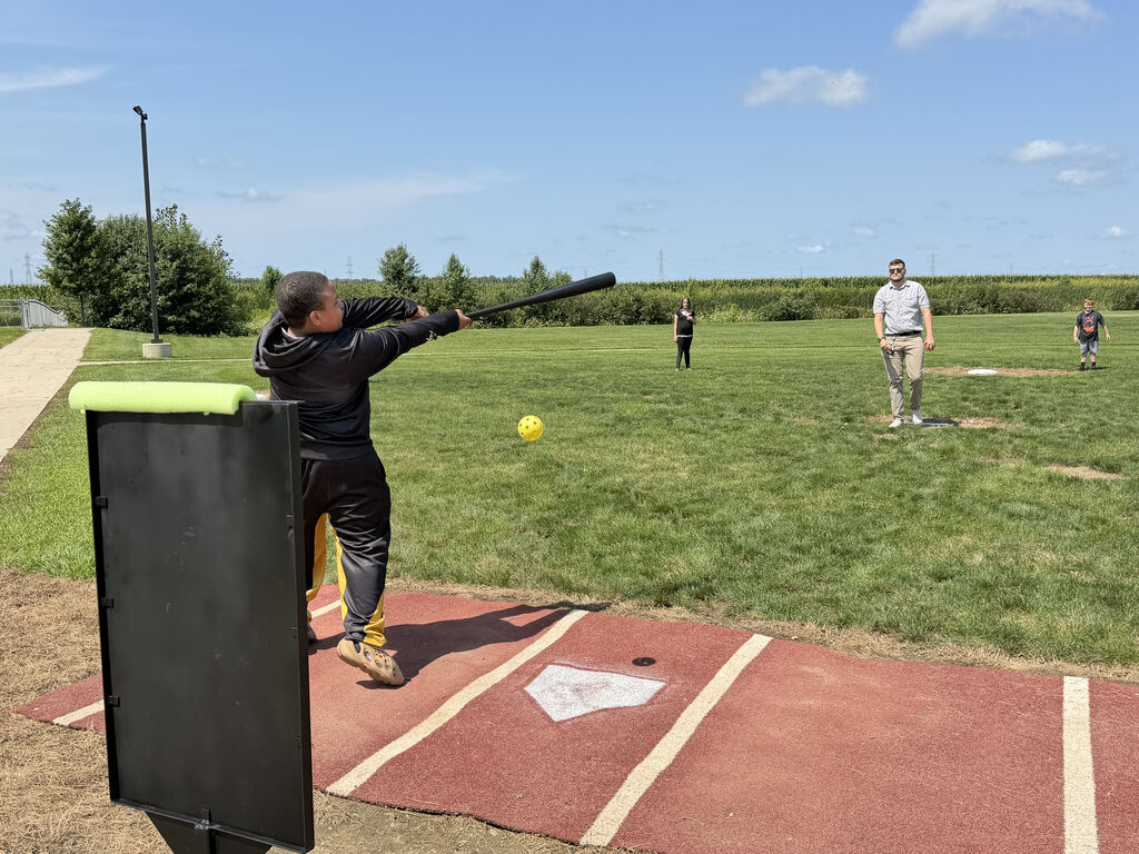 teacher and student playing wiffle ball