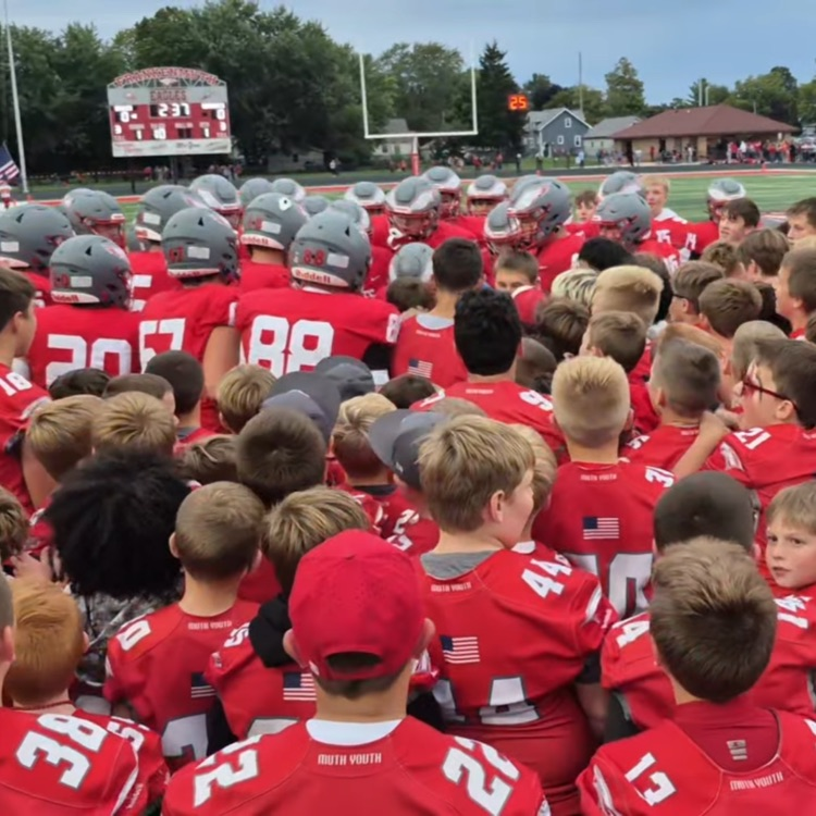 football varsity surrounded by youth players in pregame