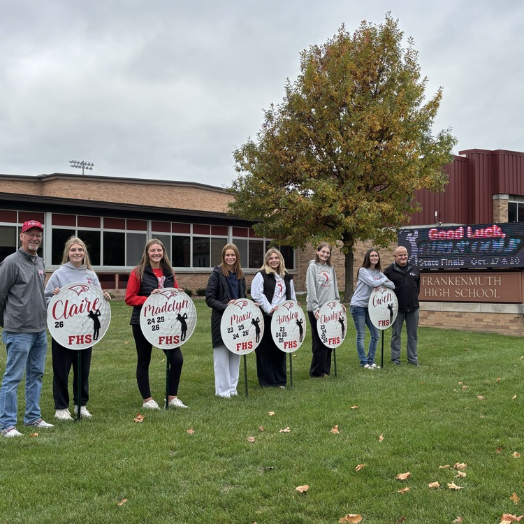 girls golf team poses in front of school signs