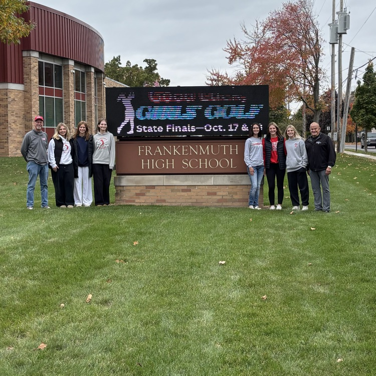 girls golf team poses in front of school sign