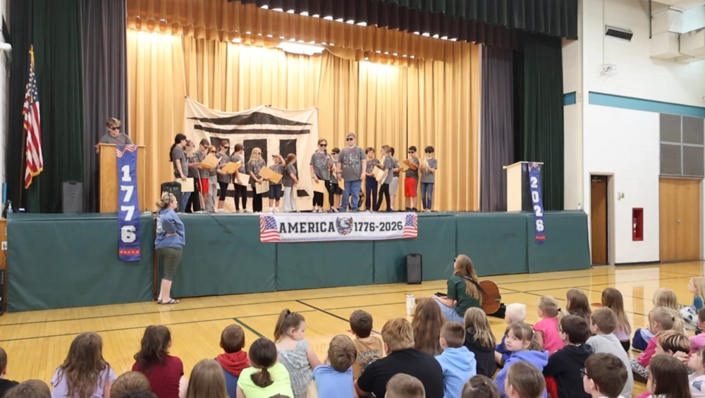 Students on stage performing play for school