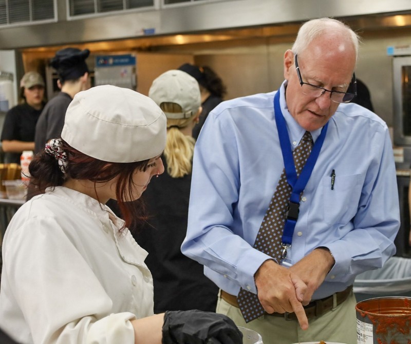 Prinicpal, Dean Yando and senior student discussing her dish