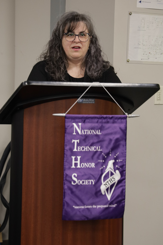 Co-advisor Paula Erno-Boyea speaking at podium