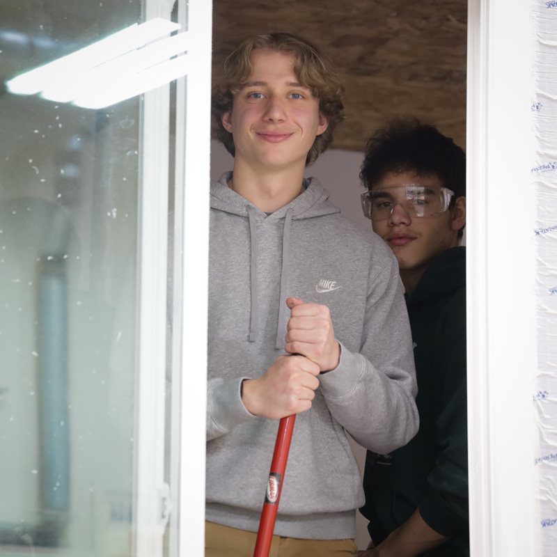 Students in concession stand smile out of window