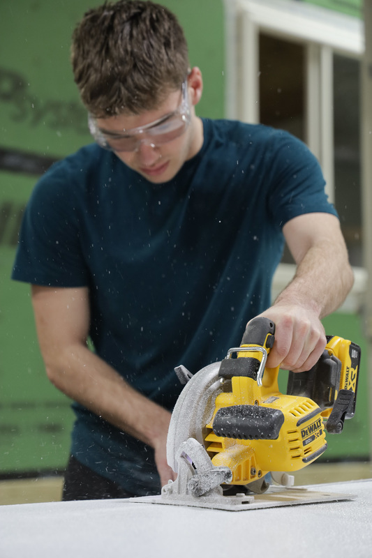 building trades student cutting a panel