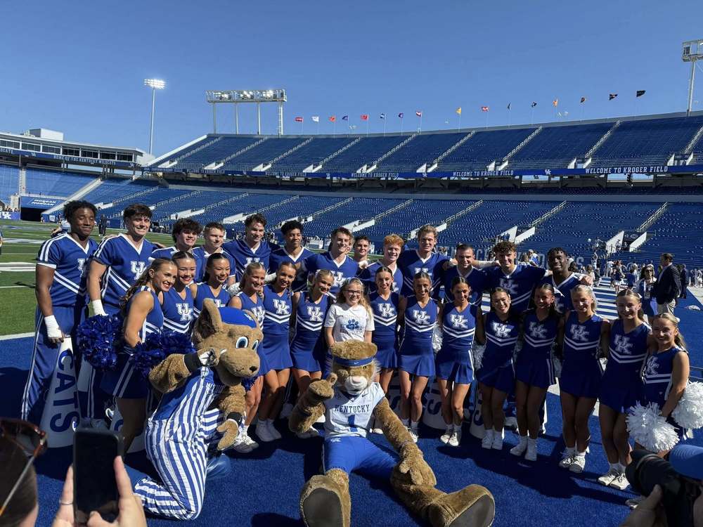 Molly with UK Cheer team and mascots on Kroger Field