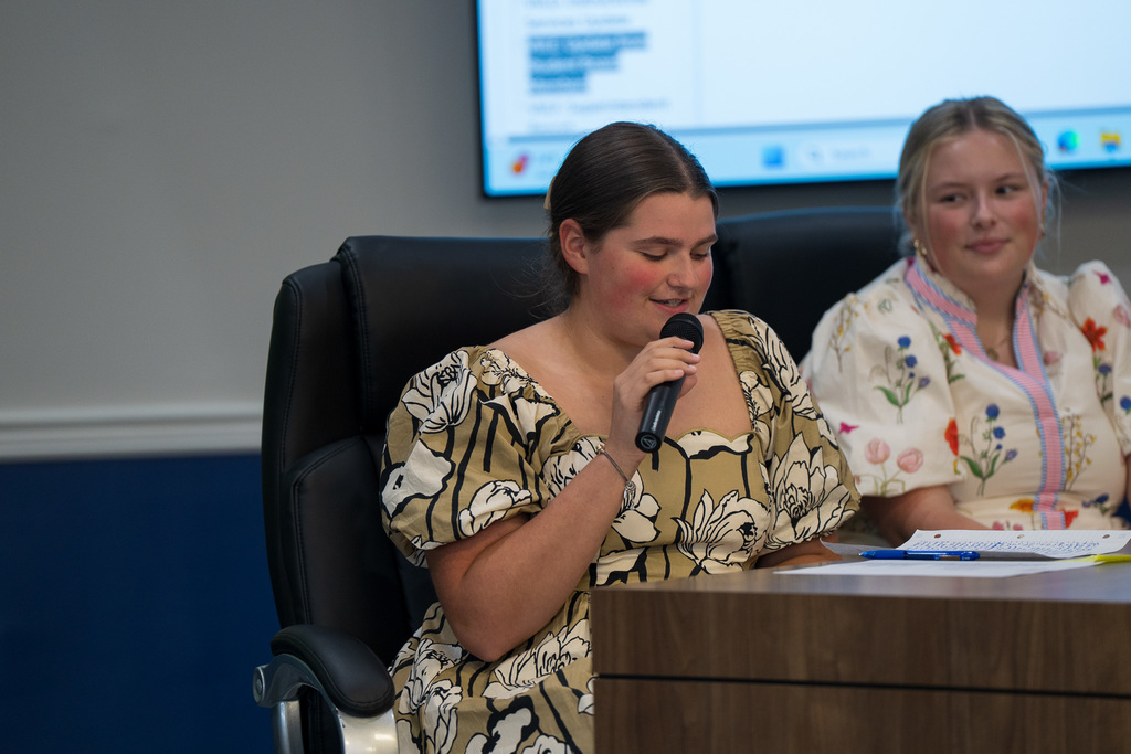 bekah has the mic at a board meeting