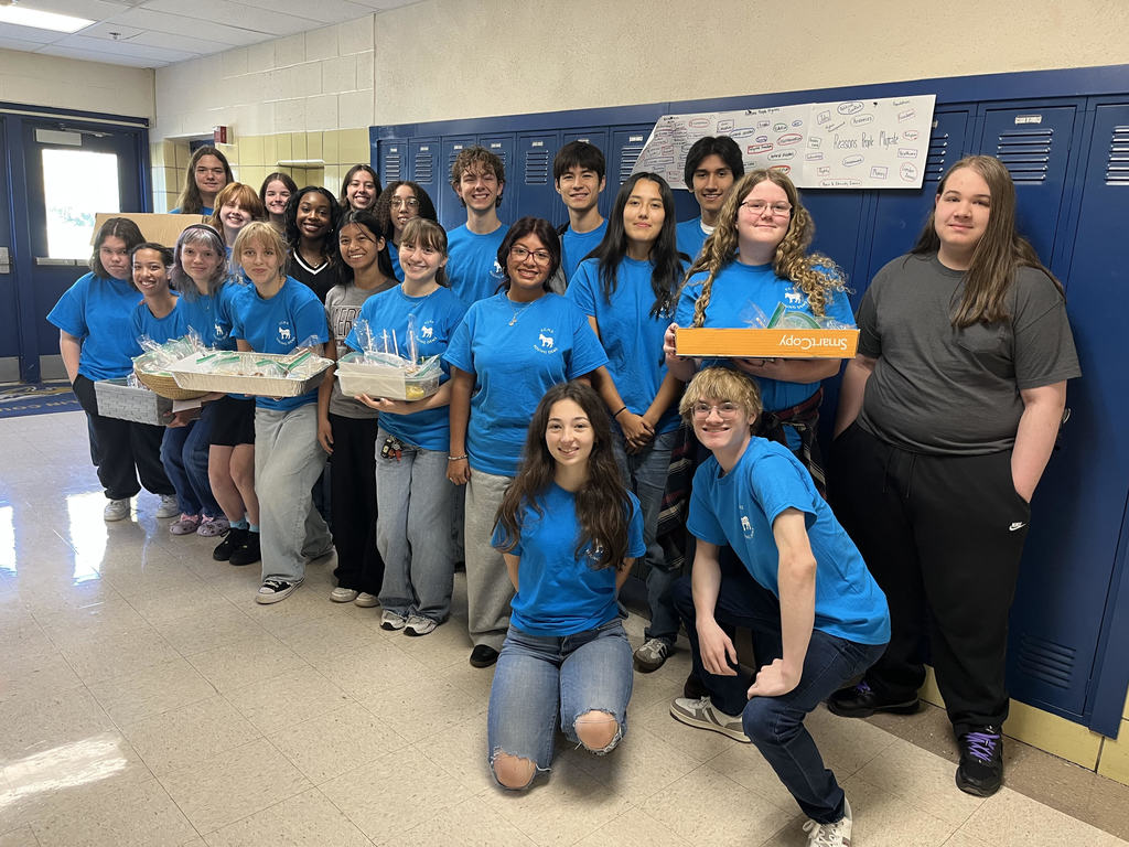 A group od students in the FCHS Young Democrats Club holding baked goods in a school hallway