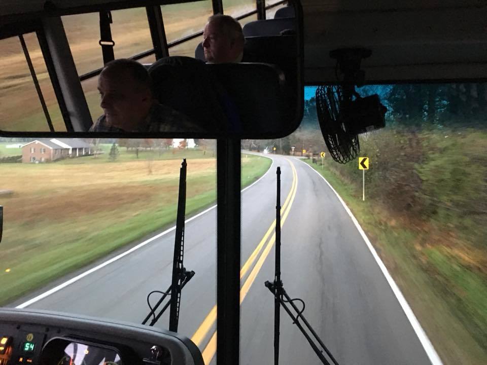 bus driver driving a bus with windshield wipers going