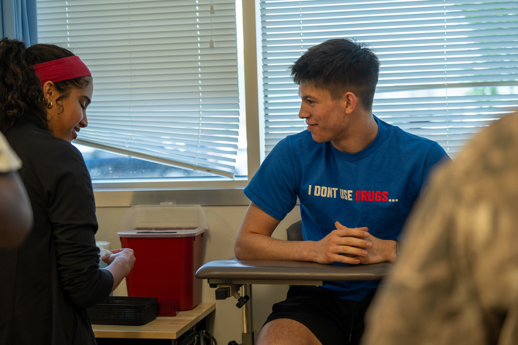 Phlebotomy students practice drawing blood from local volunteers and their peers.