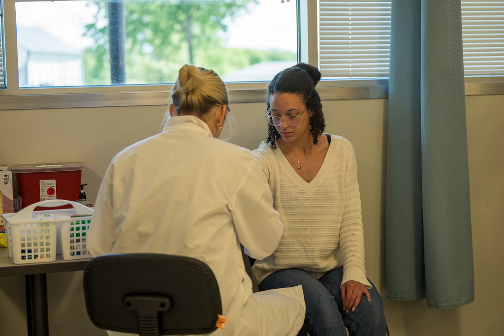 Phlebotomy students practice drawing blood from local volunteers and their peers.
