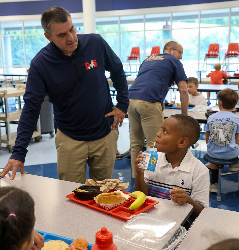 Peaks Mill Elementary Principal talks to student in the cafeteria.