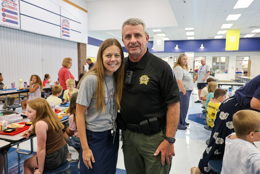 Peaks Mill Elementary teacher and school resource officer pose for a photo.