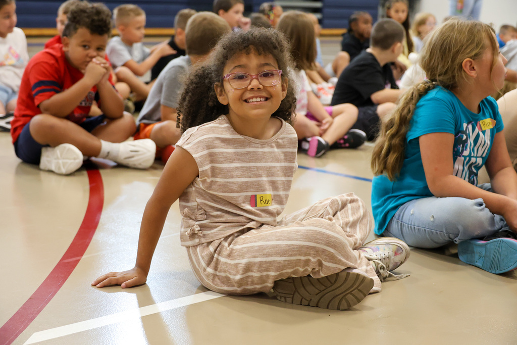 Peaks Mill Elementary student smiles for a photo in the gym.