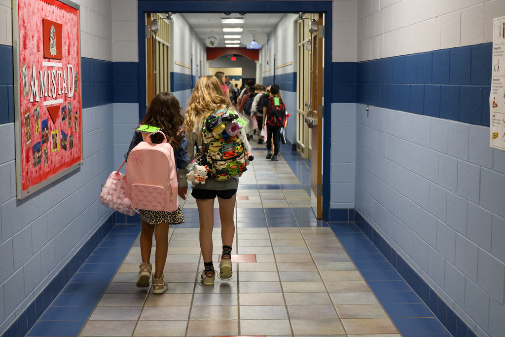 Two students walk down the hallway.