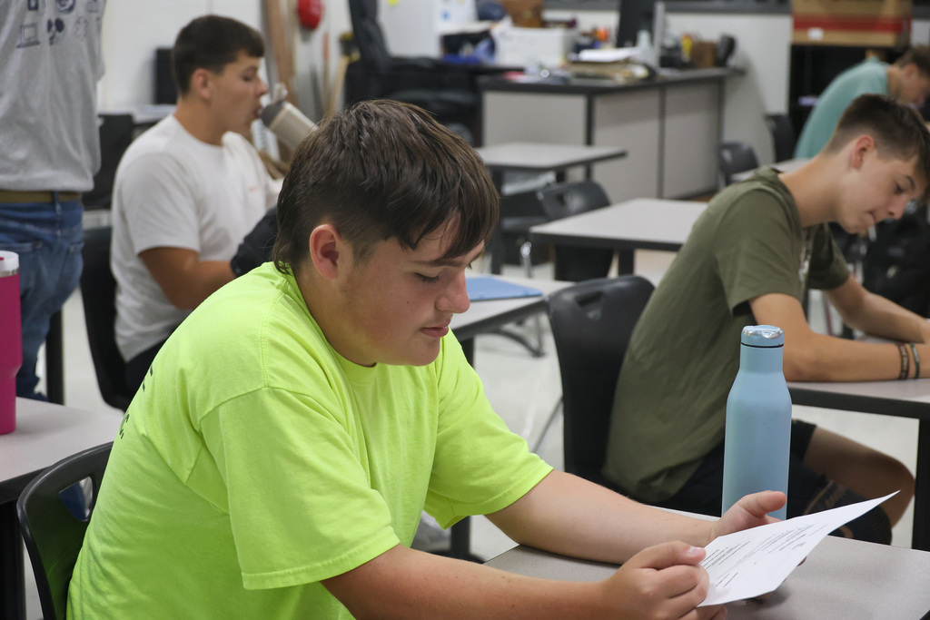 Student reads piece of paper in a classroom.