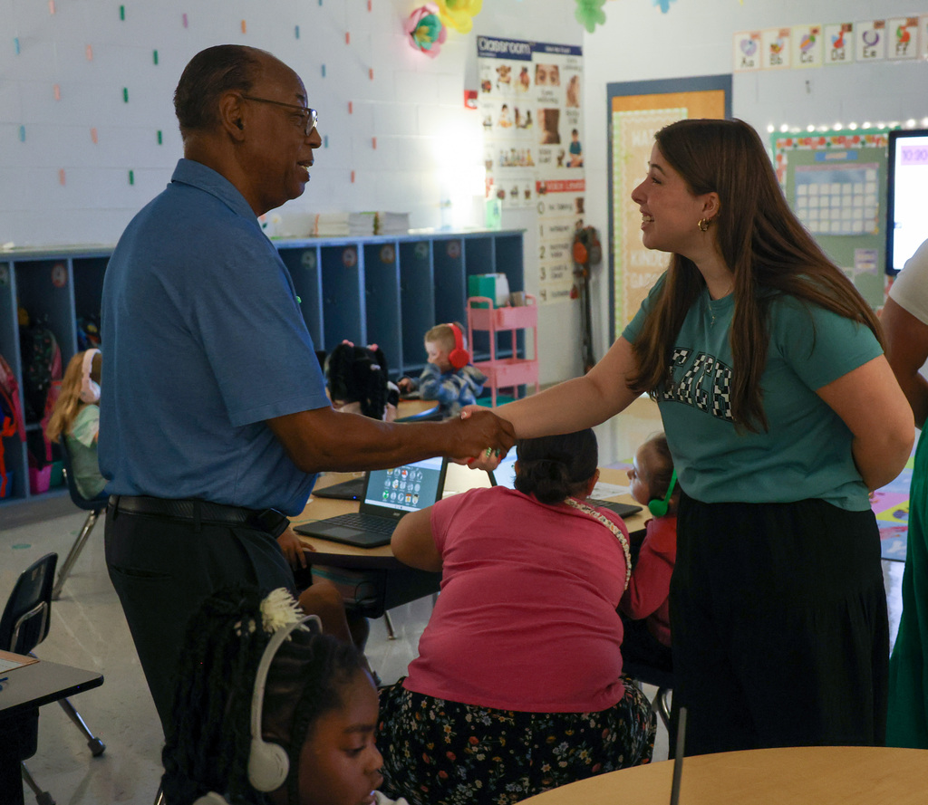 Board member Chuck Fletcher shakes hands with a Kindergarten teacher.
