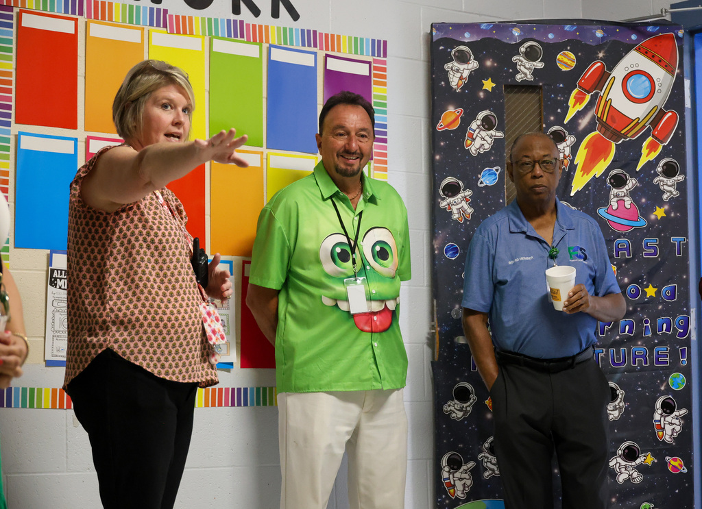 Principal Lynette McKinney (left) shows a preschool classroom to board members Larry Perkins and Chuck Fletcher.