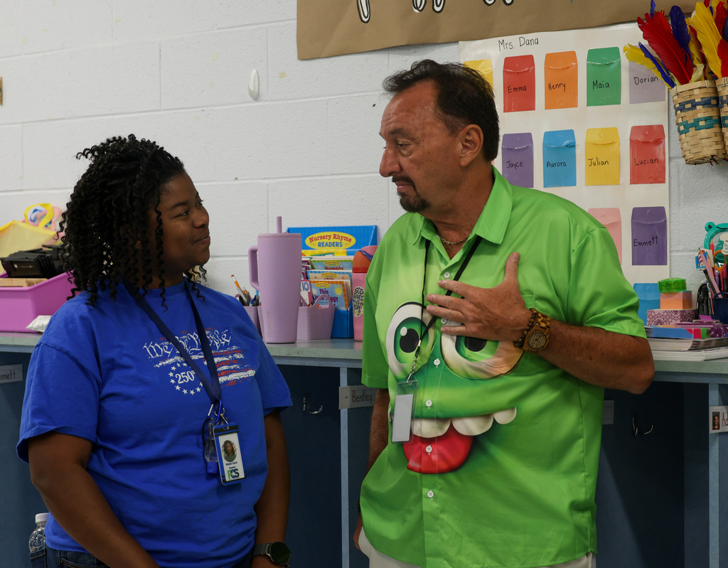 Board member Larry Perkins talks with a preschool staff member.