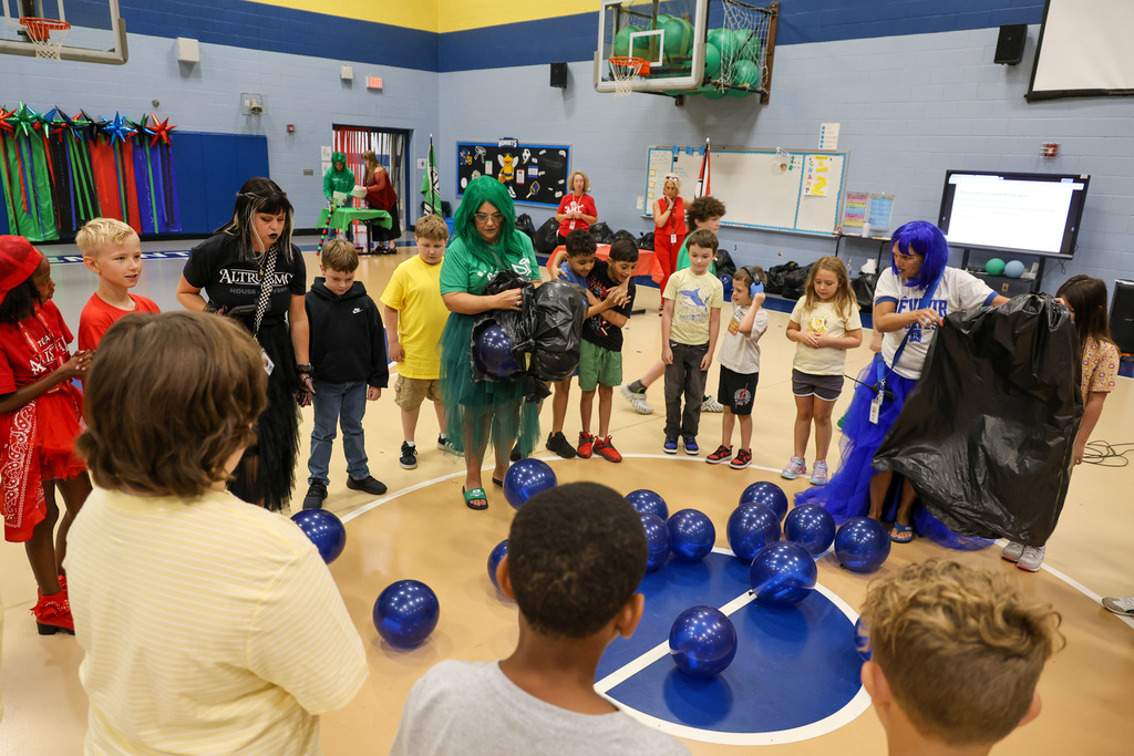 Students stand in a circle as they prepare to pick a balloon and pop it to find out their nest.