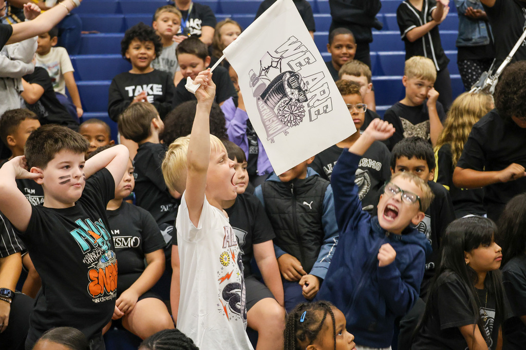 Student holds Altruismo flag up high and cheering.