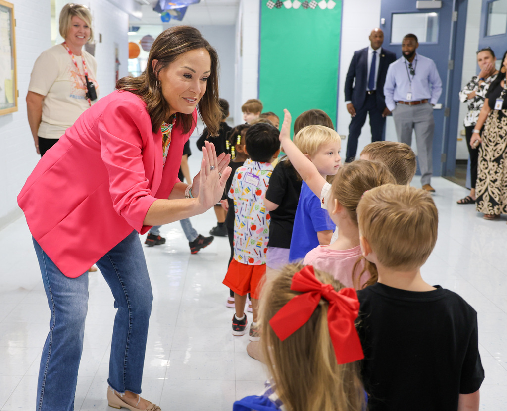 Lt. Governor Jacqueline Coleman gives a high-five to a preschool student.