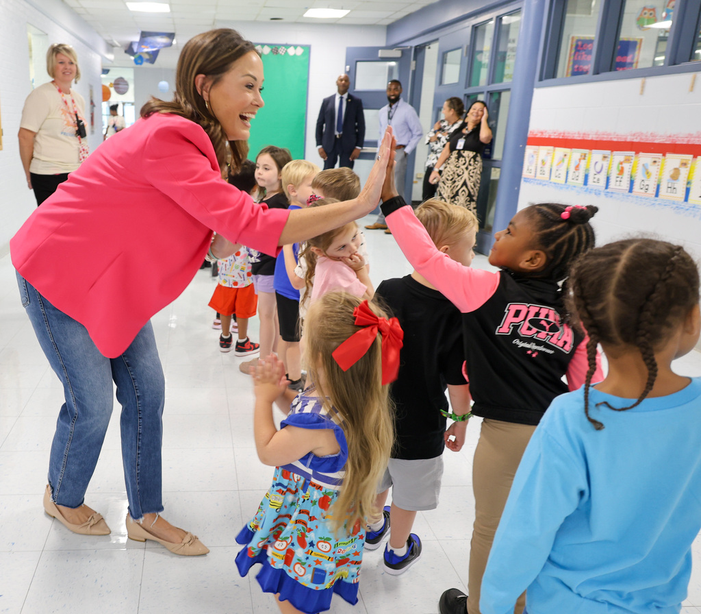 Lt. Governor Jacqueline Coleman gives a high-five to a preschool student.