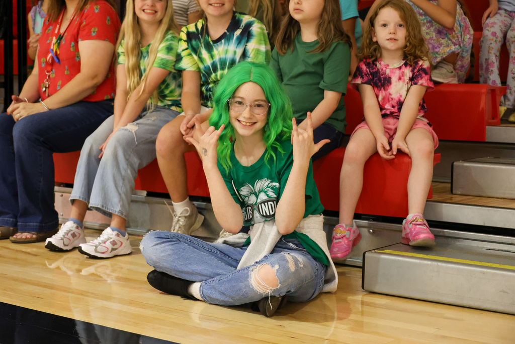 Student has a green wig and shirt on to represent her house of Isibindi, the House of Courage.