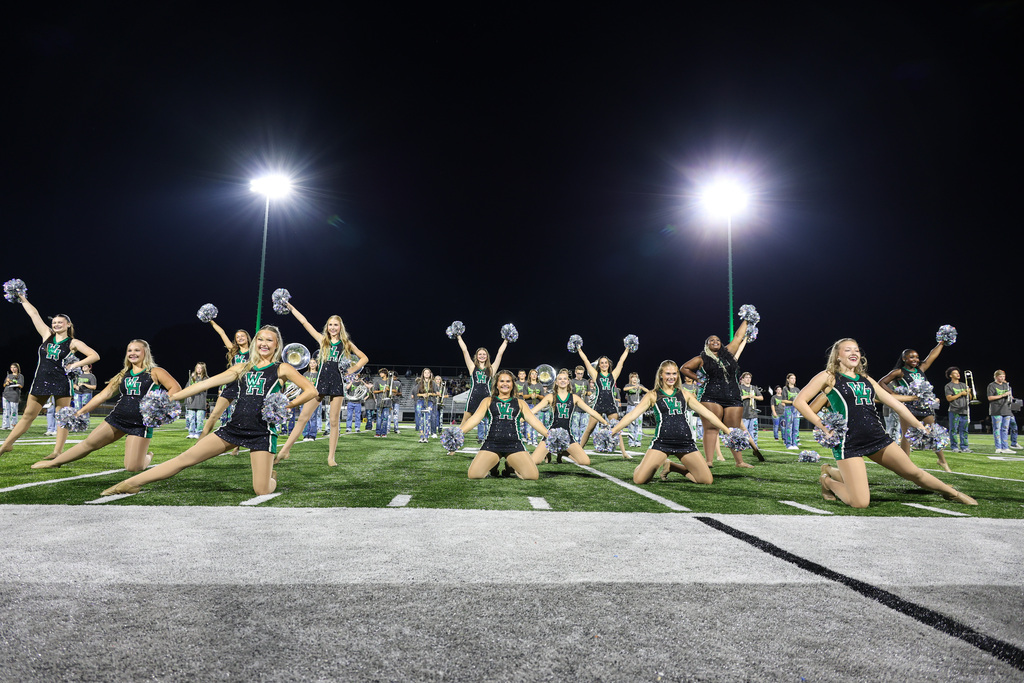 WHHS Dance Team performs on the field with the band behind them.