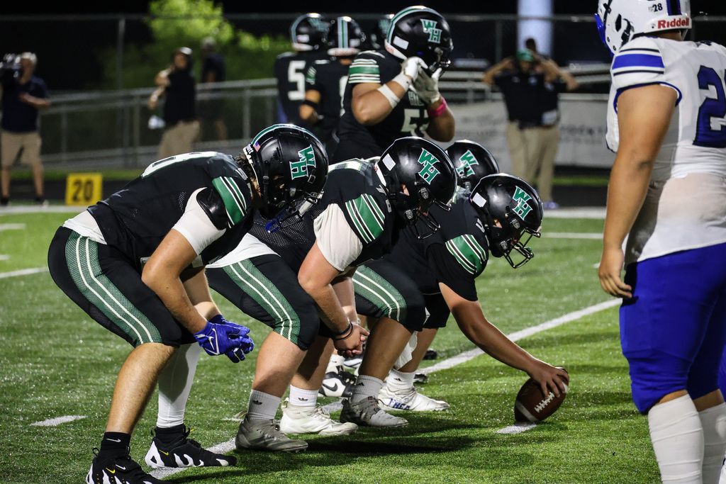 WHHS football team prepares for a play on the field.