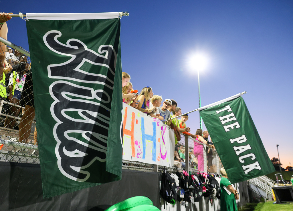 WHHS students hold two flags that say "Hills" and "The Pack"