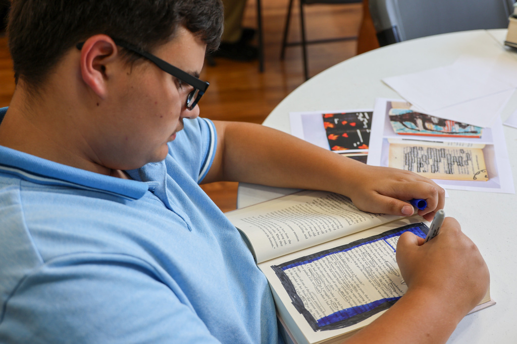 Academy student uses a sharpie to "black out" parts on the page.