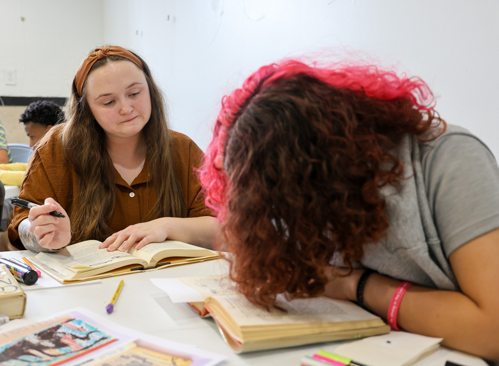 Academy teacher observes student circling words in her book.