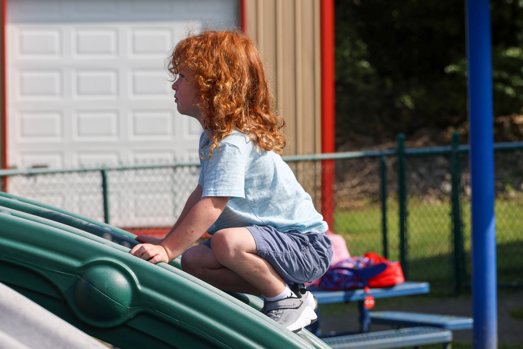 Preschool student climbs the playground.