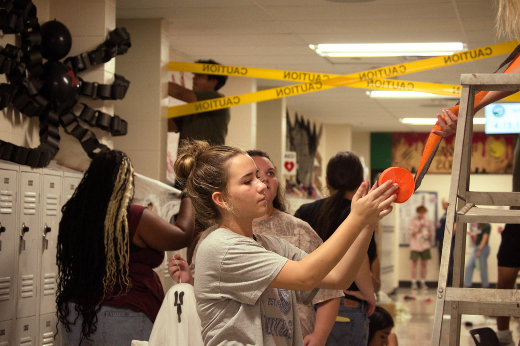 WHHS student helps decorate the hallway for homecoming week.