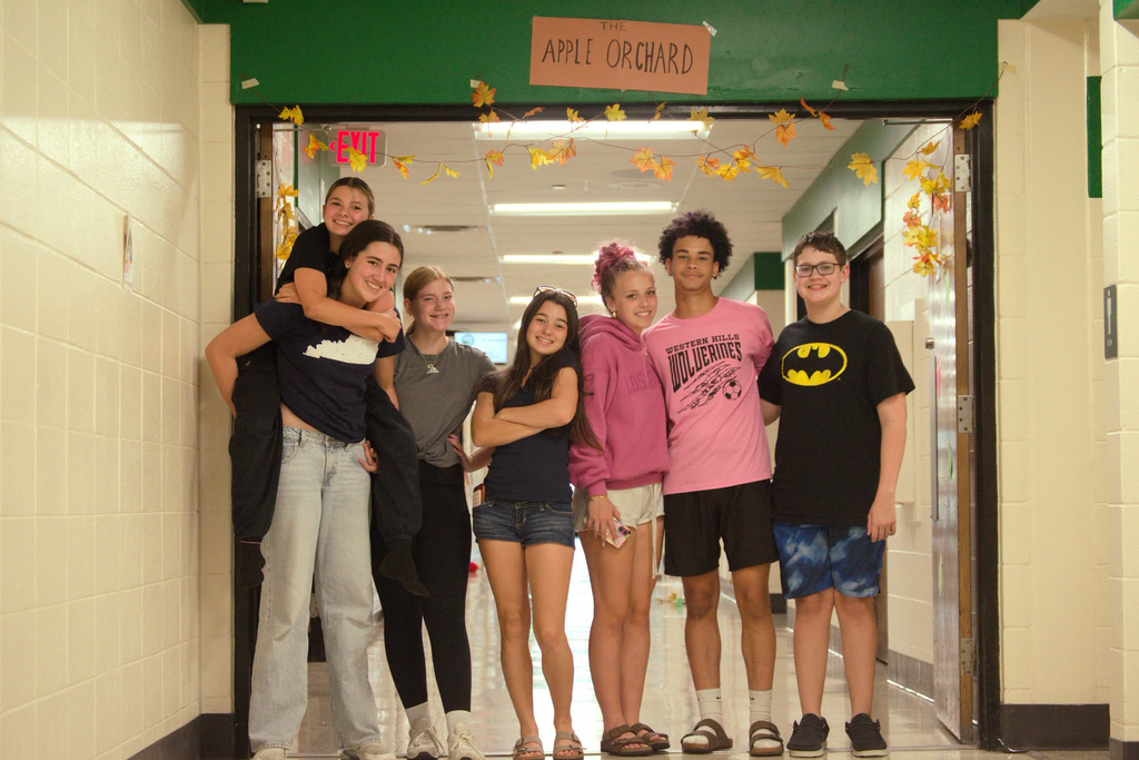 Group photo of students standing in front of their "Apple Orchard" hallway.