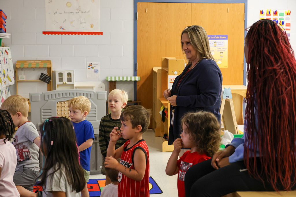 Dr. McDonald stands with students in a classroom.